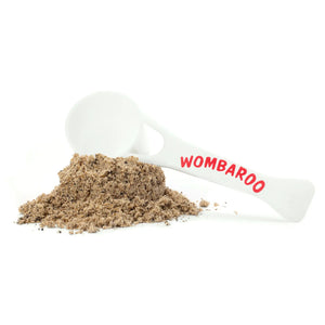 Image of the powdered form of Insectivore Rearing Mix spread out on a white background, backed by a Wombaroo-branded scoop that comes with the box.
