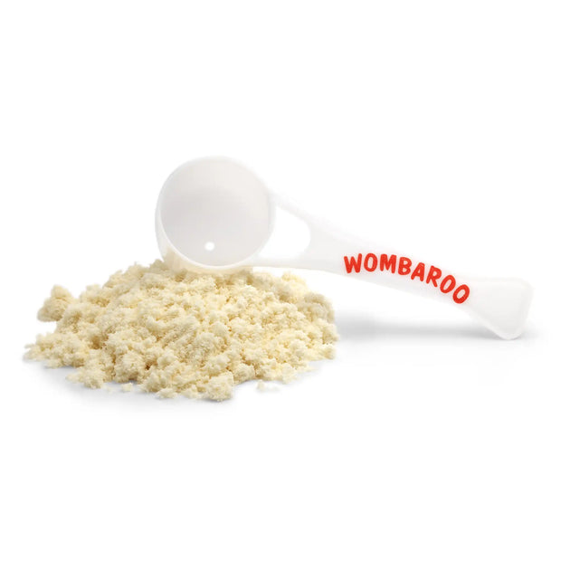 Image of powdered Wombaroo milk replacer, alongside a Wombaroo-branded scoop that comes with the box.